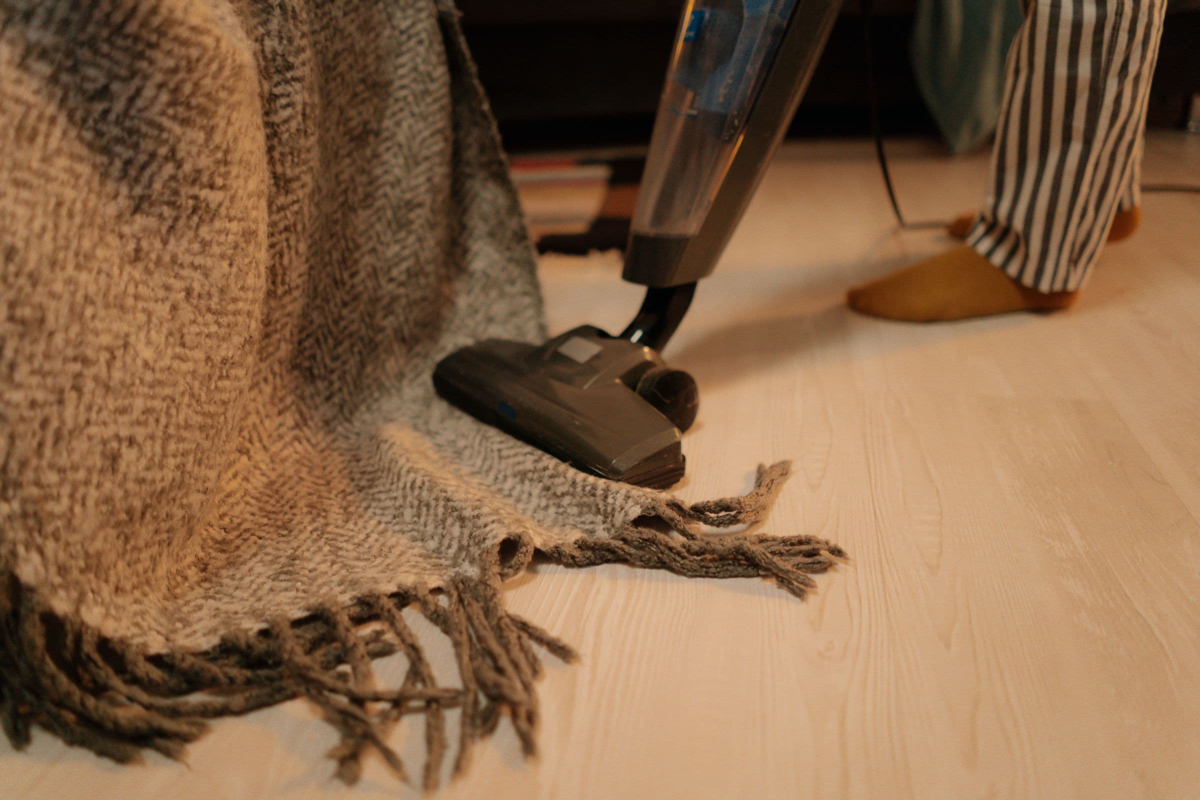 Vloerkleed wordt gestofzuigd op een lichte houten vloer